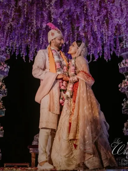 The couple standing under a breathtaking floral mandap, a testament to grand and beautiful wedding decor.