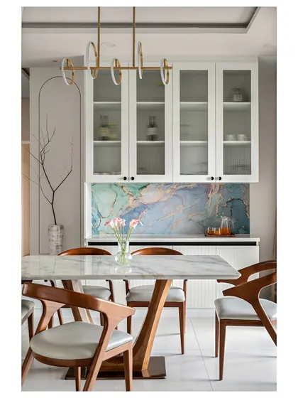 This dining area features a stunning blue marble-finish laminate backsplash, which provides the luxurious look of real stone at a more accessible price point. Paired with elegant wooden chairs and a modern pendant light, it creates a space that is both artistic and functional.