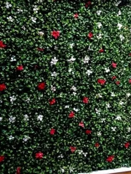 A full view of the artificial wall with scattered red and white flowers. This is a great option for a balcony or terrace wall that needs a pop of color.