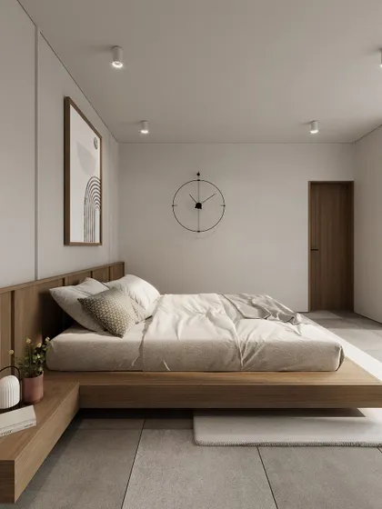 A Japanese-inspired minimalist bedroom with a low platform bed and clean white walls. The design emphasizes simplicity and natural materials.