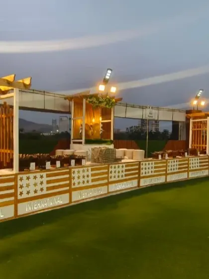 A stylish outdoor buffet setup on the lawn of Ellora Banquet hall. The wooden structures and warm lighting create a modern and inviting dining experience for guests.