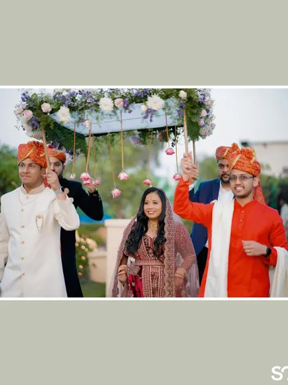 The bride's grand entrance under a beautiful floral canopy held by her brothers, a touching and visually stunning moment.