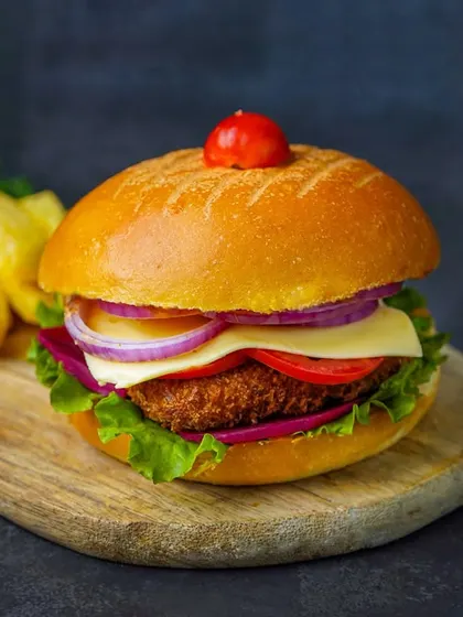 A detailed shot of a crispy burger, highlighting the texture of the patty and the fresh vegetables.