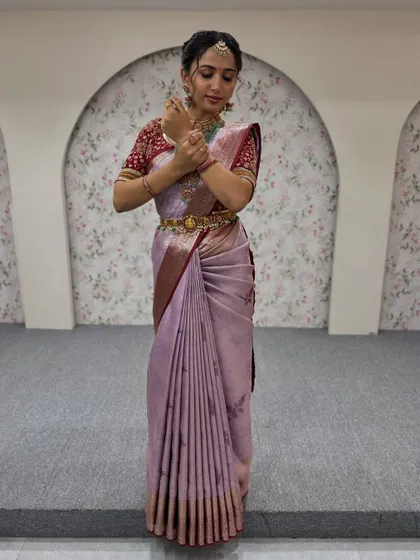 A full view of this elegant party look. The soft lavender saree is draped to perfection, complemented by a statement necklace and a braided hairstyle.