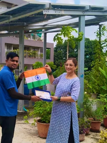 A customer proudly displays the Indian flag on her lush green rooftop after our team completed the solar installation.