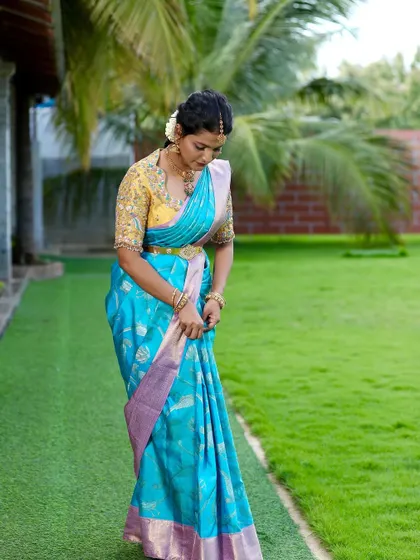 The drape of the saree is just as important as the weave itself. Here, Kavya adjusts her pleats, showing the graceful fall of the pure silk.