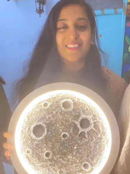 A close up of a participant and her glowing moon lamp, capturing the magic of the workshop.
