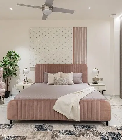 A wider view of the pink bedroom, showing the bed, a floral accent chair, and a sleek dresser, all custom-made by us for this special project.