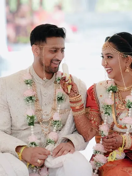 A sweet moment where the bride playfully feeds the groom during their South Indian wedding ceremony.