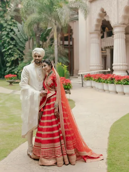 A classic portrait of the bride and groom against the stunning architecture of The Leela Palace, Bengaluru. I help couples find those perfect photo opportunities within their grand celebration.