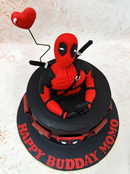 We bring the "Merc with a Mouth" to the party with this striking Deadpool cake. A detailed figure of the anti-hero sits atop a sleek black cake, complete with his utility belt and a heart-shaped balloon for a touch of his signature humor.