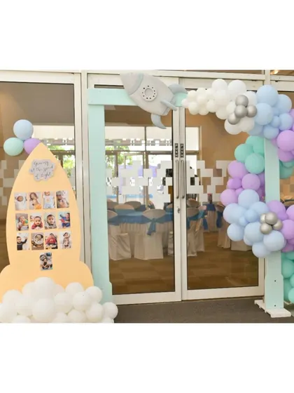 A rocket-shaped photo board and a space-themed entrance arch, creating an out-of-this-world welcome for guests.
