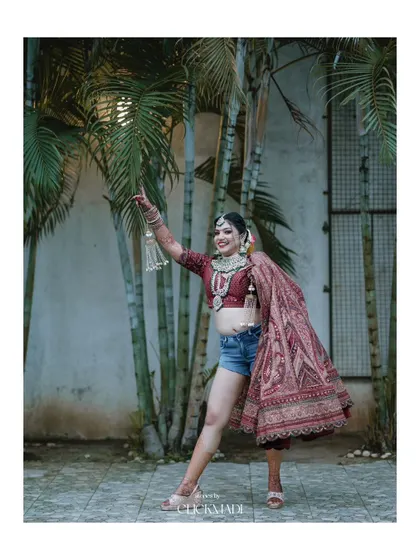 A fun and carefree bridal portrait, showcasing the modern bride's playful spirit as she poses in her wedding top and shorts.