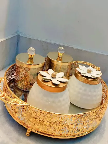 A showcase of some of the beautiful, reusable jars I use in my hampers. This set includes four decorative jars on a mirrored, filigree gold tray, perfect for adding a touch of elegance to any home.