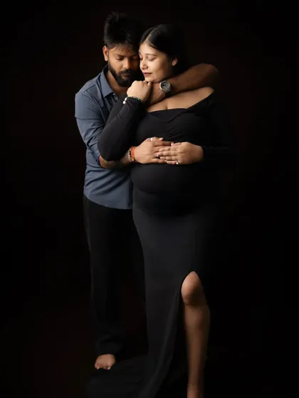 An embracing pose that shows the partner's protective and loving nature. He wraps his arms around the mother-to-be from behind, both focused on the new life they've created.