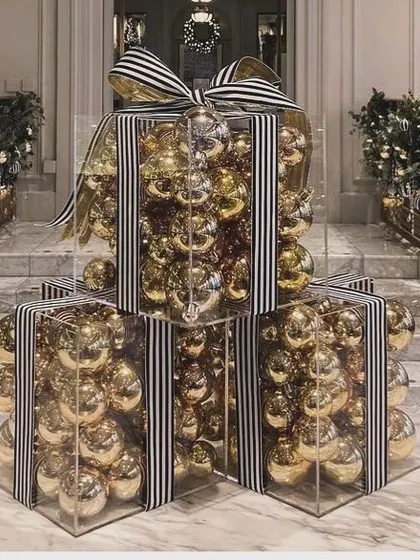 At our company, nothing comes simple, especially not Christmas decor. We created these giant, luxurious gift box installations made of clear acrylic, filled with gold baubles, and tied with a striped ribbon.