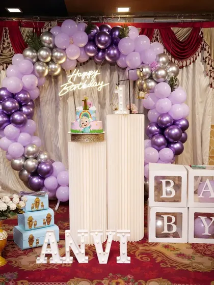 A lovely first birthday party with a purple and silver Cocomelon theme. The ring arch and 'BABY' blocks complete this classic setup.