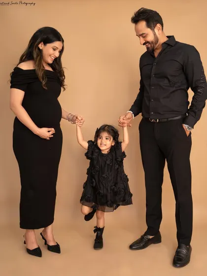 A playful moment during a studio maternity shoot. Holding hands and swinging their daughter, this photo perfectly captures the fun and happiness of this growing family.