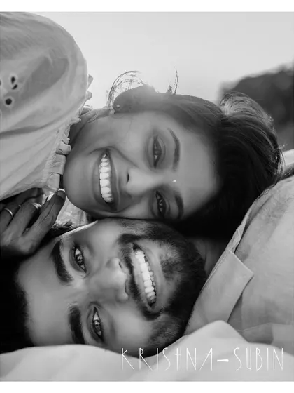 A happy, upside-down black and white portrait of a couple, full of laughter and personality.