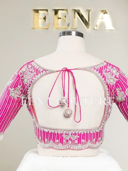 Pretty in pink, this raw silk blouse features intricate pearl and silver thread work in a striped pattern. I added floral motifs and delicate danglers on the sleeves for a touch of playful elegance.