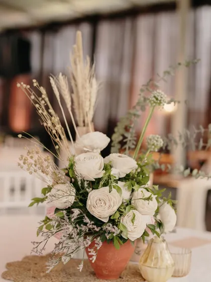 A centerpiece for a vow exchange ceremony, featuring dried flowers and pampas grass in a terracotta pot.