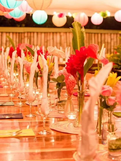 A long table set for a traditional Sajjan Koth dinner, decorated with tropical flowers and colorful paper lanterns. We take great pride in arranging this important pre-wedding ceremony with the respect and lavishness it deserves.