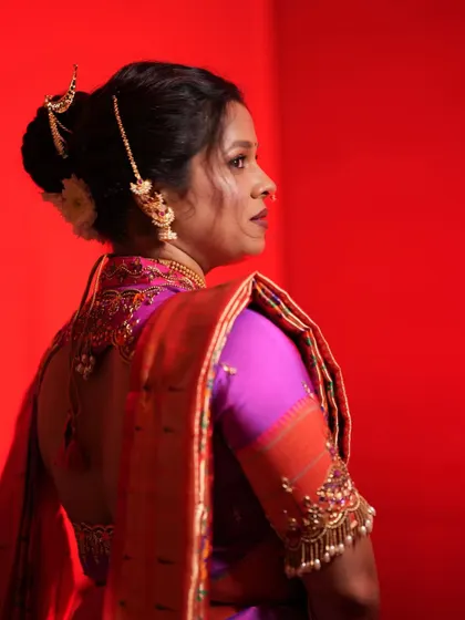 This view from the back showcases the intricate blouse design and the beautifully crafted bridal bun with elegant hair jewelry.