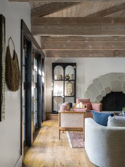 A side view of the Saratoga living room, showing how we layered different textures and materials. The smooth leather of the sofa, the rough stone of the fireplace, and the natural wood of the ceiling beams all work together to create a rich sensory experience.