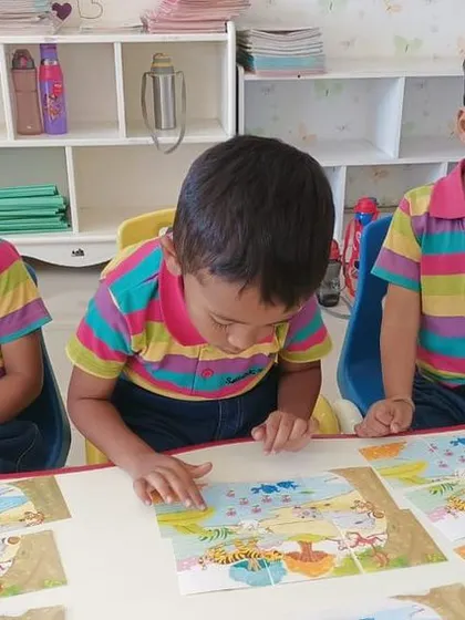 Students focus intently on finding the right puzzle pieces. Puzzles are an excellent tool for developing spatial awareness and critical thinking.