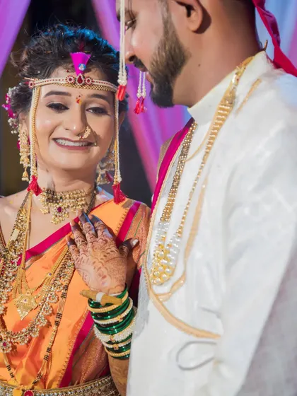 A tender moment between the bride and groom, her hand on his chest, their smiles reflecting their happiness.