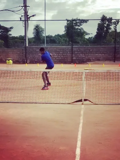 A player practices his net game, executing a jump volley. My advanced training covers all areas of the court, including aggressive play at the net.