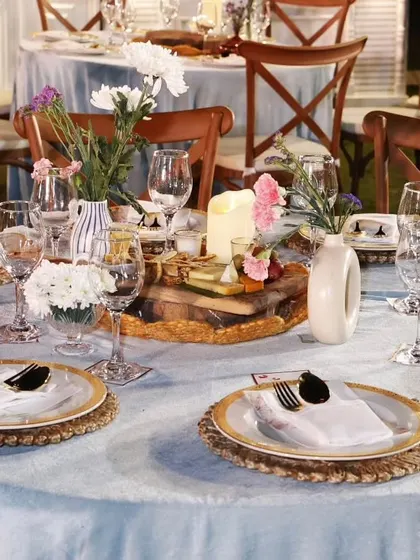 A close-up of the table setting for Ezekiel's celebration. We used woven placemats, gold-rimmed plates, and a simple floral centerpiece to achieve a look that is both rustic and refined.