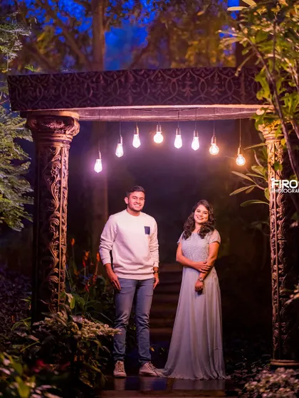 A simple yet beautiful night portrait. The couple stands under a row of hanging lights, which creates a warm and intimate atmosphere for this casual and sweet photo.