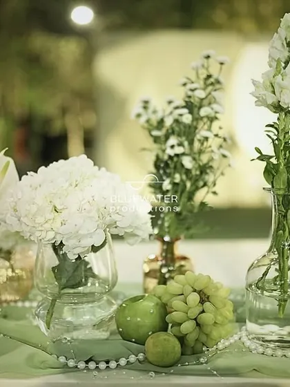 For a sage and ivory themed gala, even the fruit matches the decor. Green apples and grapes are paired with white pearls and florals for a chic centerpiece.