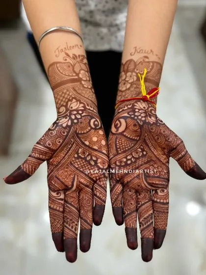 The rich, dark stain of a full bridal henna. This design features the bride's name, 'Jasleen Kaur', elegantly written amongst the floral patterns.