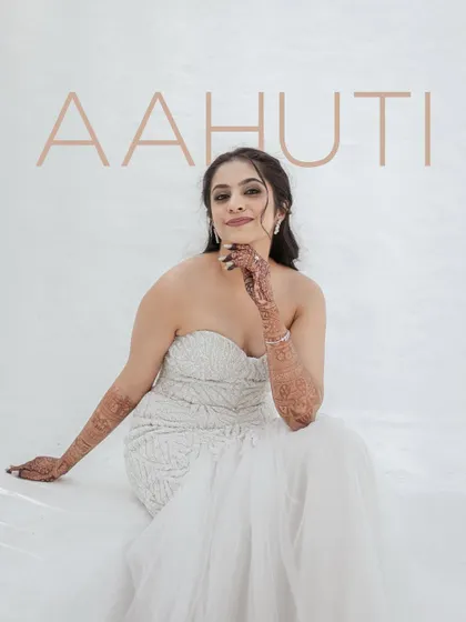 A stunning, minimalist portrait of the bride in her white gown. The simple background and elegant text highlight her grace and beauty.