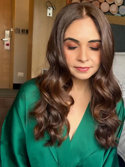Soft, glamorous waves paired with subtle, earthy-toned makeup. This look is effortlessly chic, perfect for a client getting ready for a party in the comfort of her hotel room.