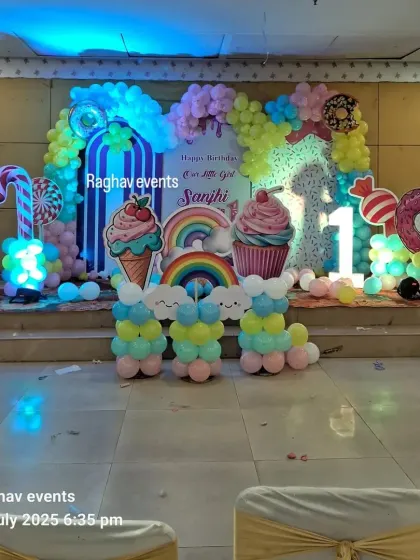 A full view of the candyland themed birthday stage, showing the complete setup with all the sweet treat cutouts and balloon decorations.