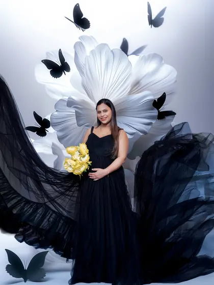 For a more whimsical feel, we added these butterfly props to the floral backdrop. It adds a layer of storytelling to this beautiful black and white themed maternity portrait.