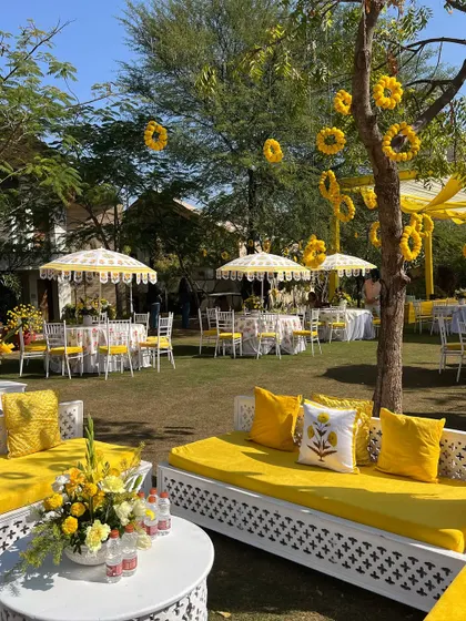 Custom-printed cushions and elegant white furniture add a touch of bespoke charm to this cheerful haldi event.