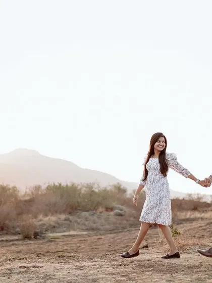 Walking hand-in-hand through the dry hills at sunset. This wide shot captures the feeling of a shared journey.