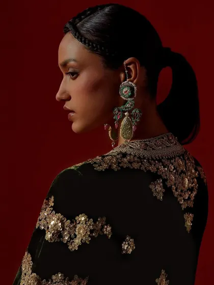 A profile shot highlighting the detailed embroidery on the back of a Debyani & Co piece and the elegant hairstyle.