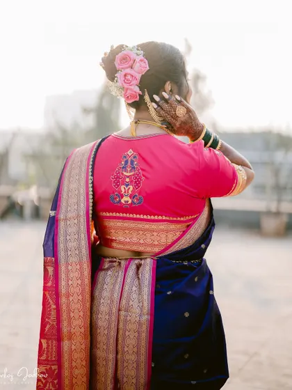A detail shot focusing on the back of the bride's blouse and her beautiful floral hair arrangement.