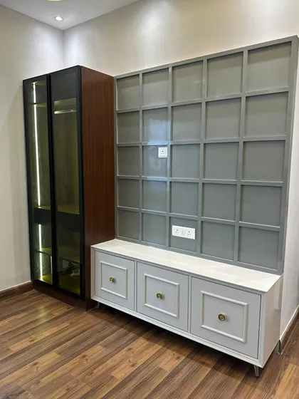 A custom-built entertainment and storage unit in a grey and wood finish. This versatile piece can serve as a media center or a stylish storage solution for a home office or study area.