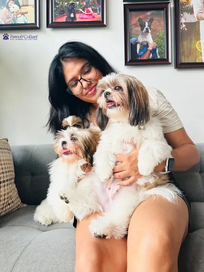 A lap full of love. This pet parent is all smiles while holding her two adorable Shih Tzus.