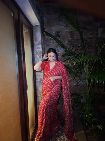 A quiet moment. The rich red of the saree and the intricate print make it a statement piece on its own.