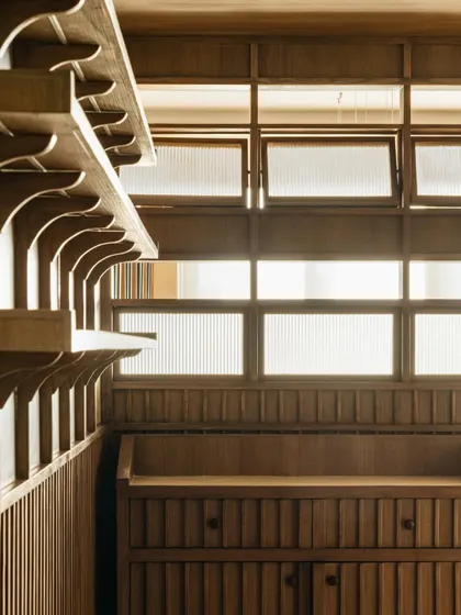 Details of the custom joinery and shelving at QBF Coffee. The design language is one of honest craftsmanship, with exposed brackets and a mix of wood and stone textures.
