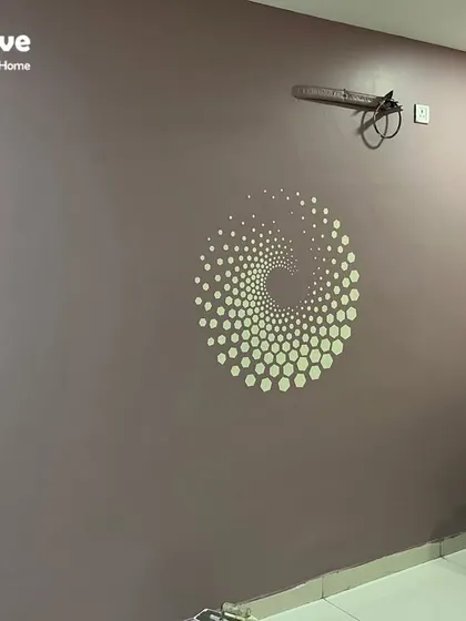 The completed 'Luxe Lithos Spiral Hex' stencil on a mauve accent wall. This modern, geometric mandala adds a single, captivating focal point to the room, blending style and simplicity.