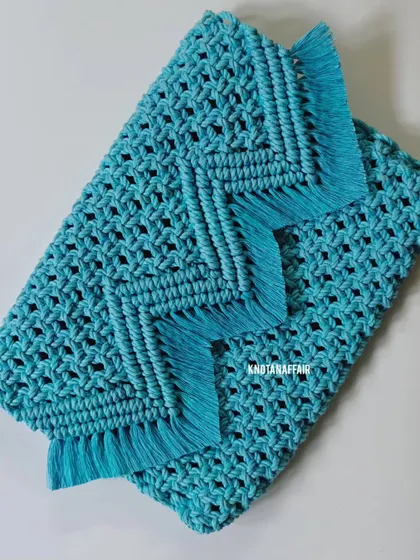 A closer look at the beautiful fringe and chevron pattern on this turquoise macrame sling bag. It's all in the details! This handmade purse is perfect for adding a boho touch to your look.