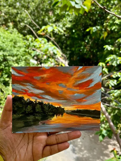 A duplicate image of the sunset painting held in my hand.